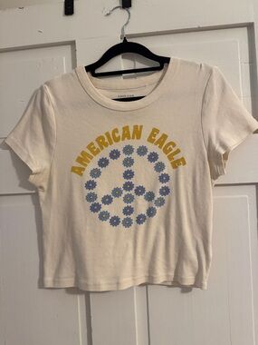 American Eagle Outfitters Cream Graphic Tee with Yellow Lettering